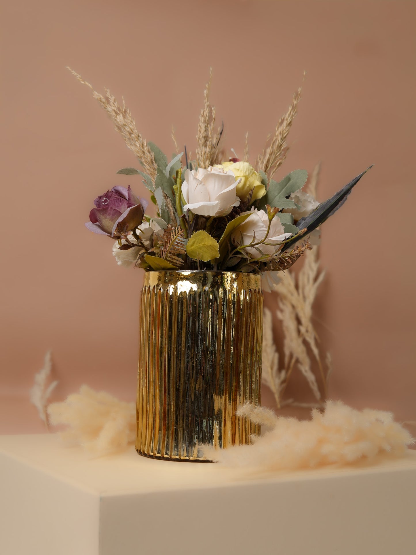 Golden metal cylindrical vase with flower bunch